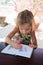 Adorable little girl drawing artwork top view on crayons in a notebook, Baby healthy and preschool concept