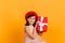 Adorable little girl in dress holding birthday present. Studio shot of child guessing what in gift