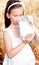 Adorable little girl drinking milk on field of wheat