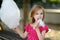 Adorable little girl eating candy-floss outdoors