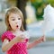 Adorable little girl eating candy-floss outdoors