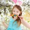 Adorable little girl eating colorful gum candies on Easter