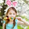 Adorable little girl eating colorful gum candies on Easter