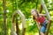 Adorable little girl enjoying her time in climbing adventure park on warm and sunny summer day