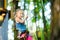 Adorable little girl enjoying her time in climbing adventure park on warm and sunny summer day