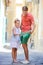 Adorable little girl and happy dad during summer italian vacation in empty narrow street