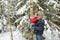 Adorable little girl and her grandpa having fun in beautiful winter forest. Happy child playing in a snow.