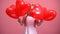 Adorable little girl hiding behind heart-shaped balloons Valentines day surprise
