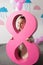 adorable little girl holding big pink decorative number eight and smiling at camera