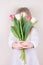 Adorable little girl holding flowers for her mom on Mother's Day