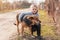 Adorable little girl hugging a large brown yard dog on a village street