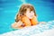 Adorable little girl with inflatable life vest having fun in the pool