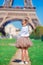 Adorable little girl near the Eiffel tower during summer vacation in Paris