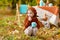 Adorable little girl on picnic in autumn park. Cute little girl  having tea party outside in the autumn garden.  Girl drinking tea