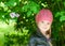 Adorable little girl in pink hat smiling in a park