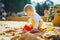 Adorable little girl on playground in sandpit