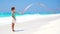 Adorable little girl playing with gymnastic ribbon on the beach. Slow motion