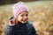 Adorable little girl in printed hat smiling at camera.