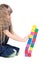 Adorable little girl push a brick toy tower