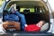 Adorable little girl ready to go on vacations with her parents. Kid relaxing in a car before a road trip.