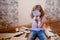 Adorable little girl repairing wall, holding putty knife