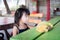 Adorable little girl sit on chair and banana comb was placed on green table in front of her.