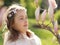 Adorable little girl is surprised and amazed looking at magnolia buds in the blooming spring garden