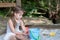 Adorable little girl with two pig tails playing in sandbox in shaded backyard
