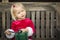 Adorable Little Girl Unwrapping Her Gift on a Bench