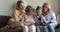 Adorable little girl using smartphone with mom grandma great grandmother