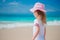 Adorable little girl walking along white sand Caribbean beach