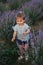 Adorable little girl walking in lavender field after sunset. Blue or purple lavender. Happy kid smile