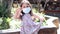 Adorable little girl wearing colorful dress and a face mask in park