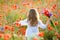 Adorable little girl with wild field flowers running thru meadow