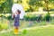 Adorable little girl in yellow rain boots and umbrella in summer