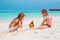 Adorable little girls at beach with colorful parrot