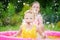 Adorable little girls playing in inflatable baby pool. Happy kids splashing in colorful garden play center on hot summer day.