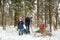 Adorable little girls and their grandpa having fun in beautiful winter forest. Happy children playing in a snow.