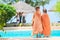 Adorable little girls wrapped in towel on the edge of pool