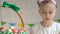 Adorable little hostess packing Easter basket with colorful dyed eggs, tradition