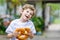 Adorable little kid boy eating huge big bavarian german pretzel.