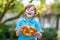 Adorable little kid boy eating huge big bavarian german pretzel.