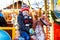 Adorable little kid boy riding on a carousel horse at Christmas funfair or market, outdoors.