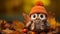 an adorable little owl wearing an orange hat and scarf on a pile of autumn leaves