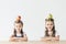 adorable little schoolgirls with apple and pear on heads sitting at table