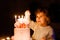 Adorable little toddler girl celebrating fourth birthday. Cute toddler child with homemade princess cake, indoor. Happy