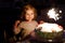 Adorable little toddler girl celebrating second birthday. Baby child eating marshmellows decoration on homemade cake