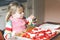 Adorable little toddler girl making italian pizza at home. Cute happy child having fun in home kitchen, indoors. Kid