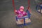 Adorable little toddler swinging on a swing in the playground