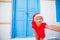 Adorable litttle girl in Santa Hat taking selfie at narrow street in greek village